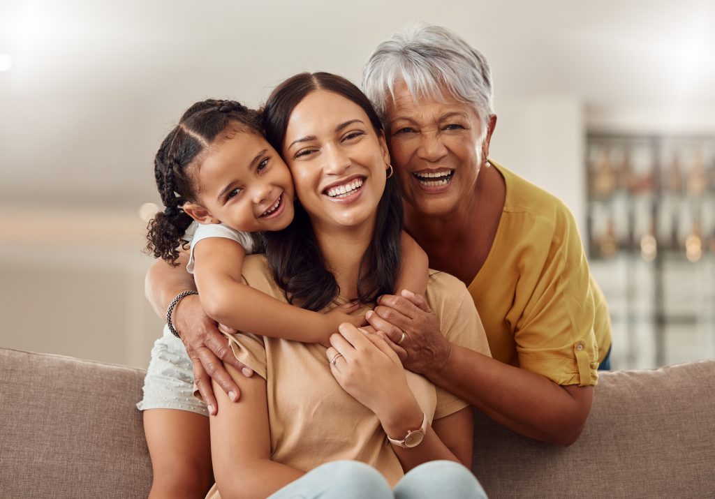 Grandmother, mother, and child hugging together
